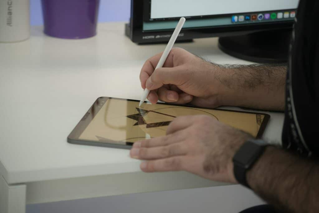 person holding white pen writing on white paper