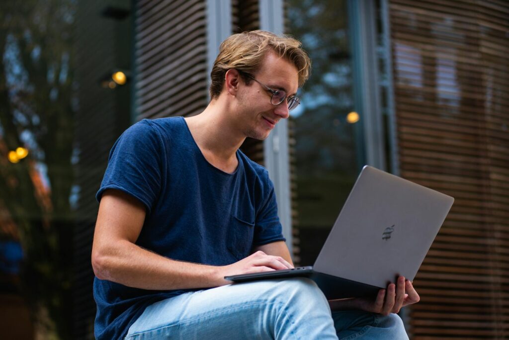The Essential Guide to Choosing the Right Small Business Consultant 6 A young man sitting outdoors in Leiden, Netherlands, working on a laptop.