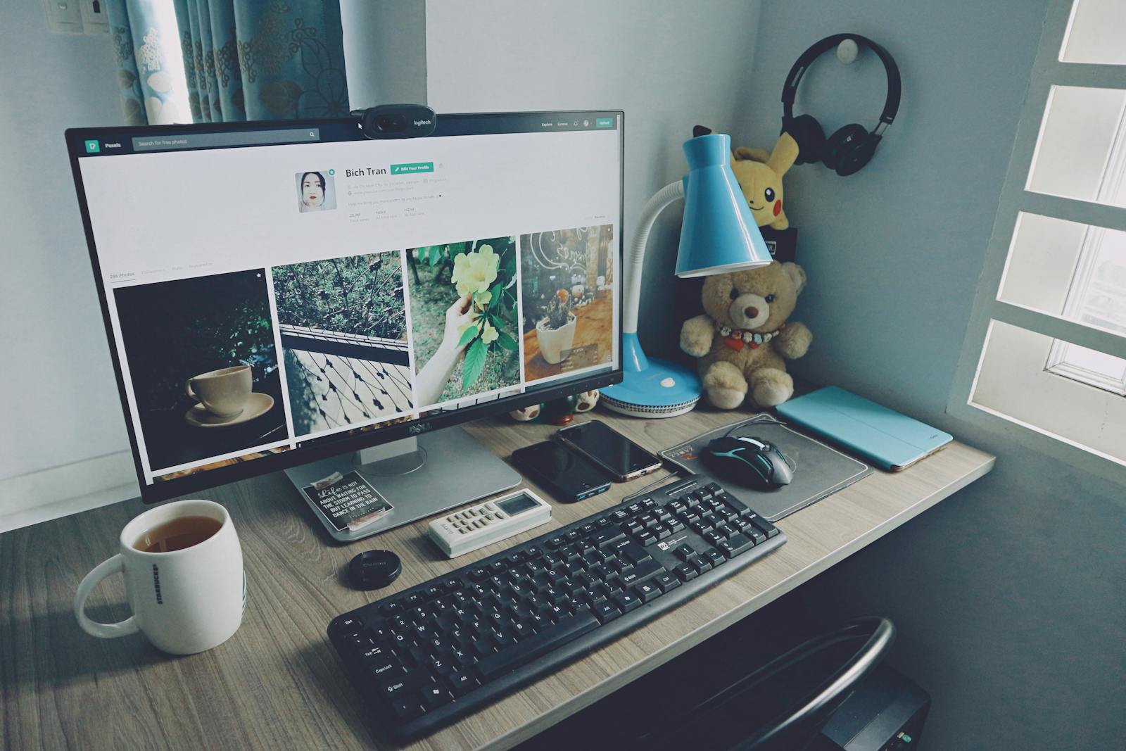 A tidy home office desk setup with a computer, keyboard, and personal items, creating a cozy work atmosphere. website ideas