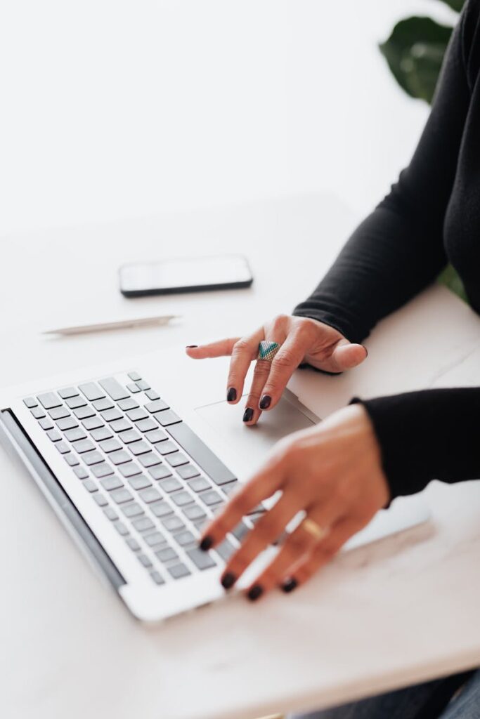 The Power of SEO Services for Small Business Success | Priceless Consulting Can Be Your Digital Marketing Solutions 5 A businesswoman's hands typing on a laptop at a bright, modern workspace.