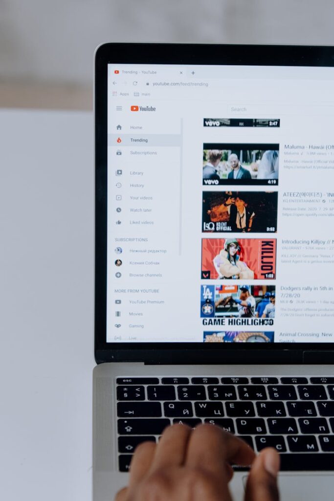 Is YouTube Considered Social Media? 7 Person browsing YouTube videos on a laptop, showcasing modern technology and online content.