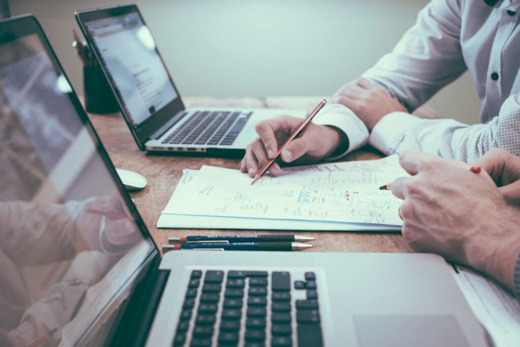 Why Small Businesses Should Outsource Web Development to Priceless Consulting 1 person holding pencil near laptop computer