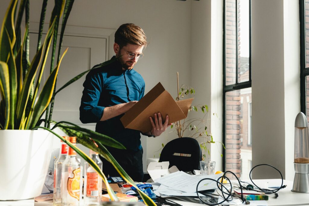 Small Business Bookkeeping Made Simple 3 a man standing in an office holding a box