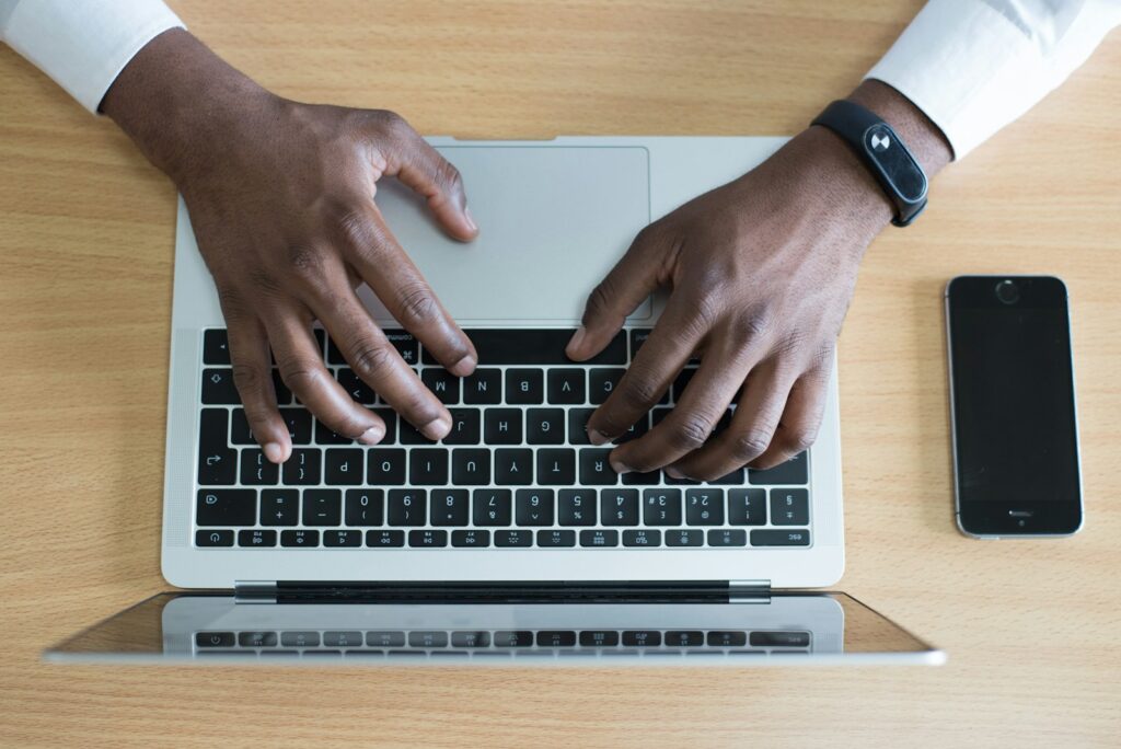 Best Email Hosting for Small Business Success in 2025 2 person's hand on MacBook near iPhone flat lay photography