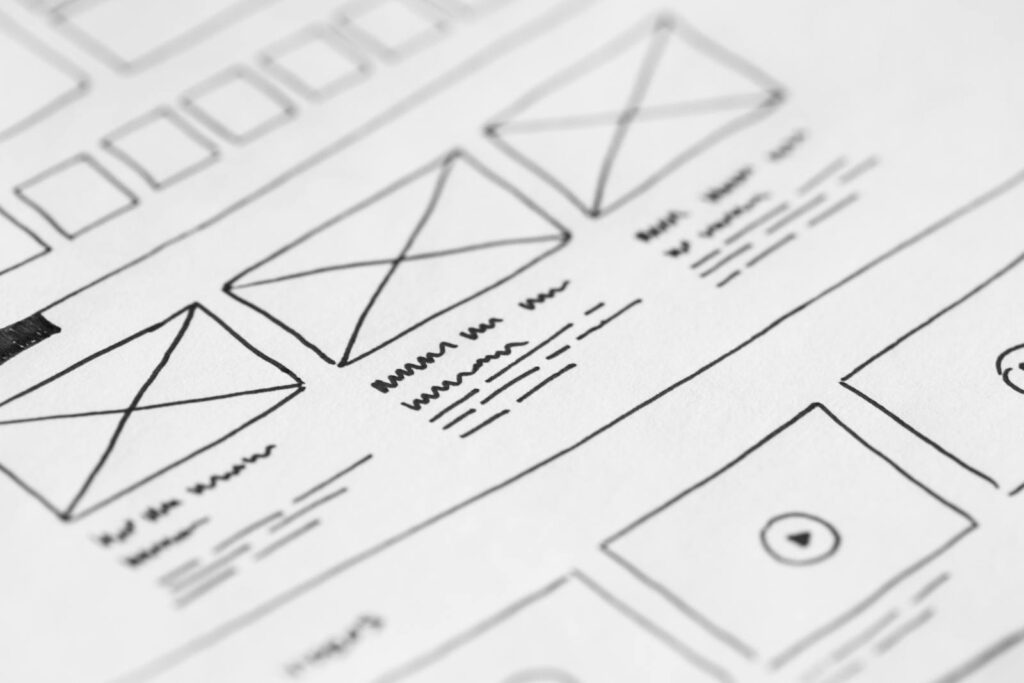 Custom Web Development at Priceless Consulting 9 Detailed close-up of a hand-drawn wireframe design on paper for a UX project.