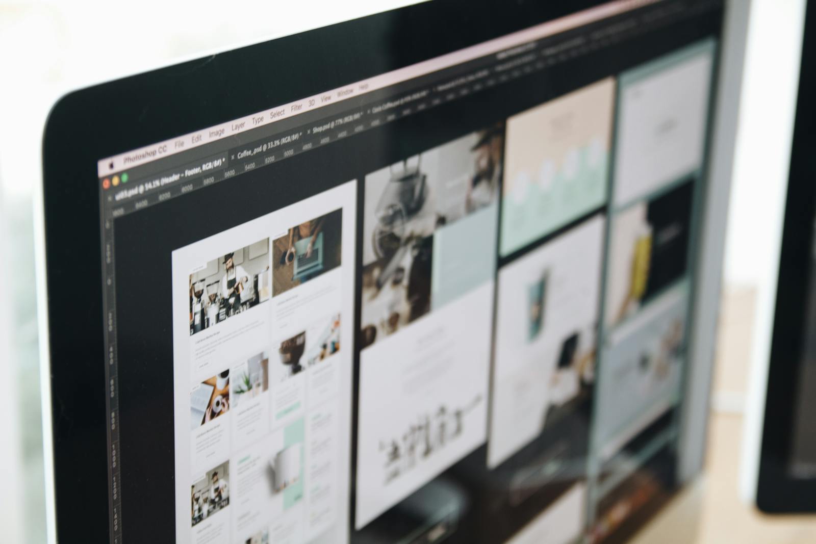 A modern computer screen displaying web design work, showcasing creative visuals in a workspace. custom web development