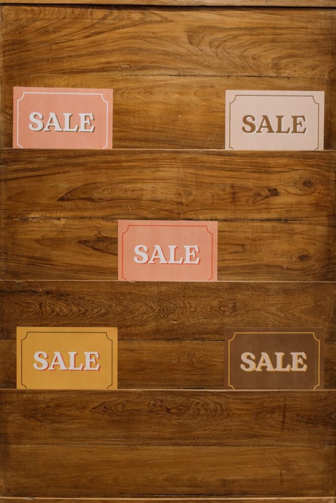Is It the End of Print Ads? | An Important Message About Advertising 5 Vertical arrangement of sale signs on a wooden background, ideal for promotions.