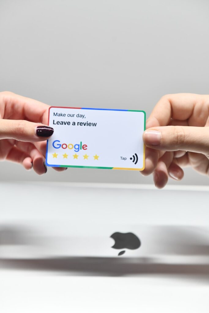 How to Delete a Google Review 2 two hands holding a google credit card in front of an apple logo