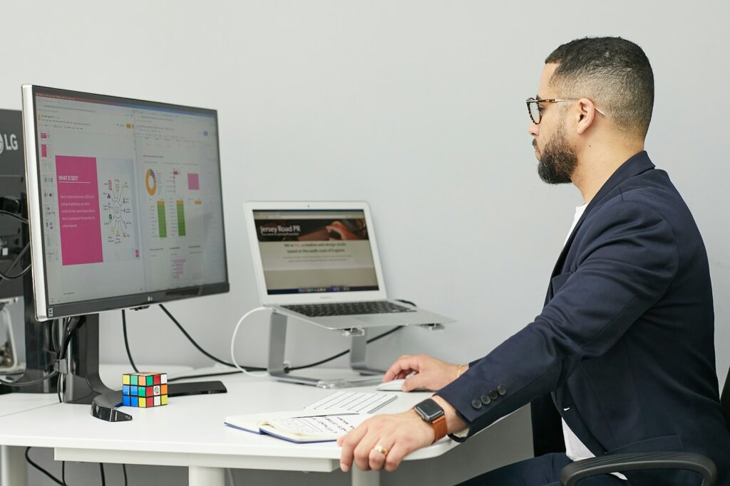 Digital Marketing Experts: Unlocking Your Business's Potential 5 a man sitting at a desk with a laptop and a computer