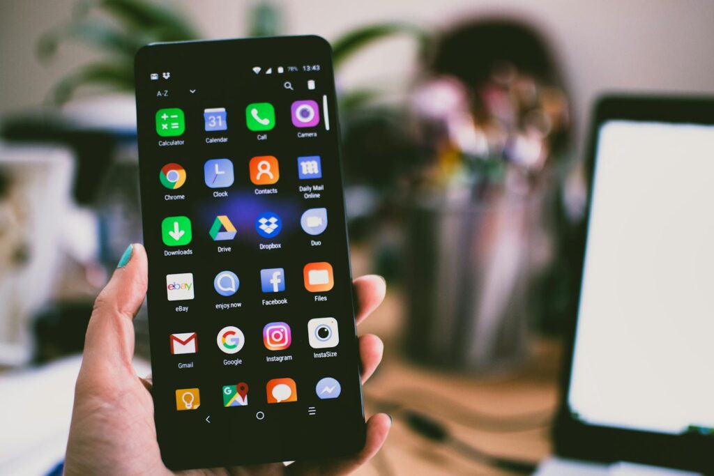 Decoding Social Media Marketing Packages: Your Complete Guide 11 A close-up image of a person's hand holding a smartphone displaying various popular apps.