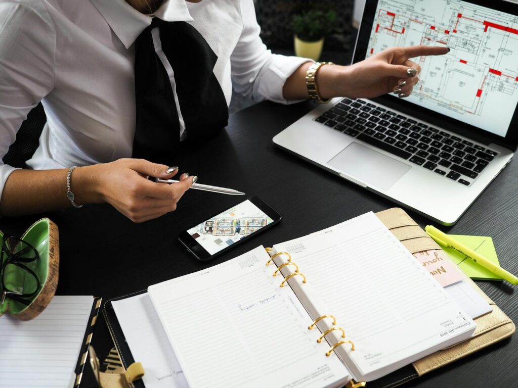 Real Estate Digital Marketing Guide for 2025 8 A business professional working on real estate project plans using multiple devices in an office setting.