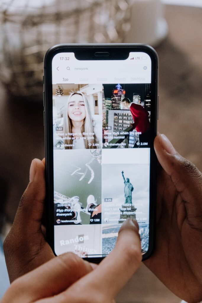 Social Media Optimization: Your Complete Guide to SMO Success 11 Close-up of a person using a smartphone to browse a social media app indoors.