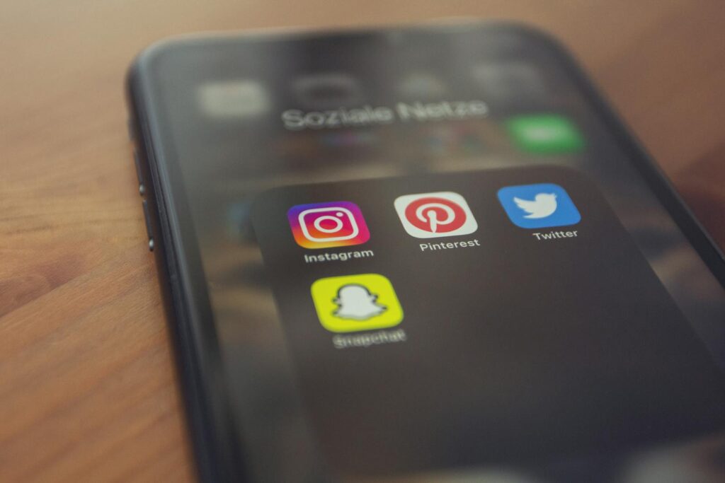 Social Media Optimization: Your Complete Guide to SMO Success 14 Smartphone displaying popular social media apps like Instagram, Pinterest, Twitter, and Snapchat.