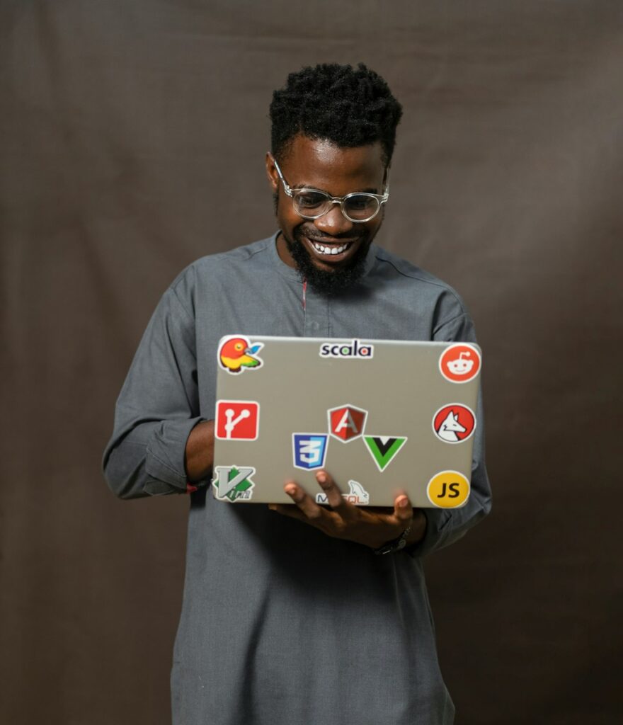Social Media Consultant: Your Complete Guide to Success 3 a man holding a laptop with a lot of stickers on it