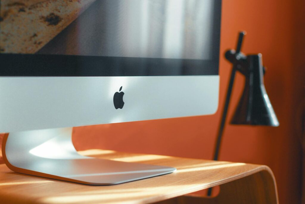 Branding Strategies: How to Build a Memorable and Profitable Brand 6 A sleek computer and stylish desk lamp on a wooden table in a modern workspace.
